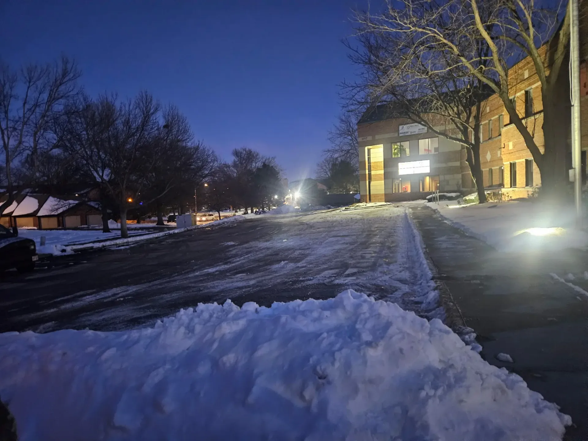 Cleared commercial parking lot at dusk after snow